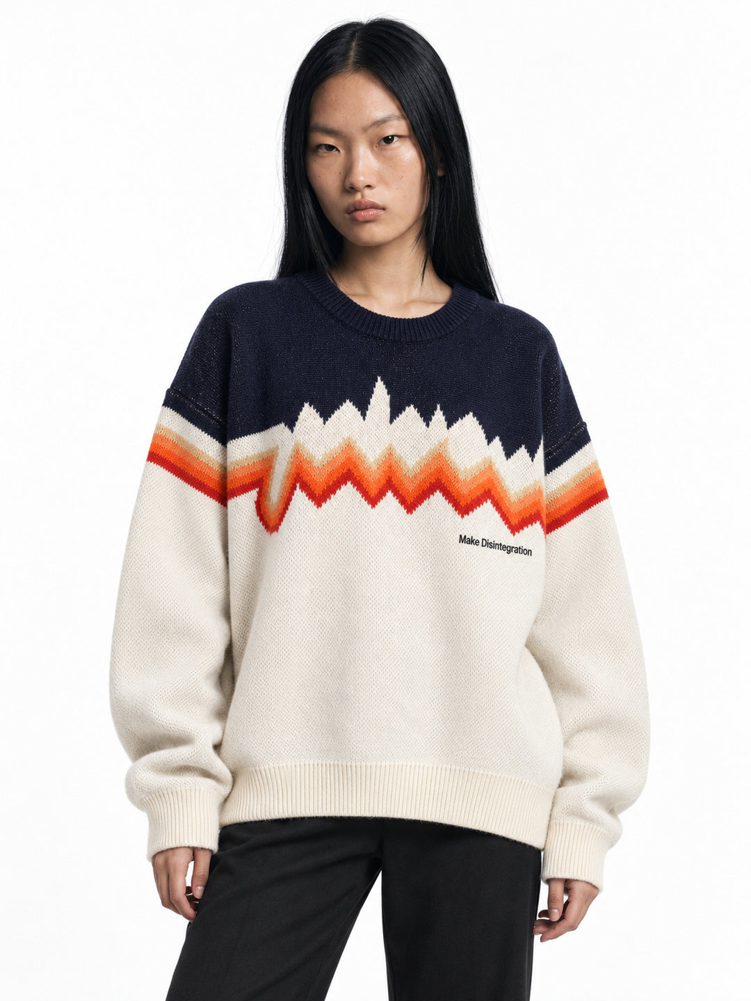 Model wearing the cream and navy Make Disintegration sweater with orange zigzag chest bands, front view.