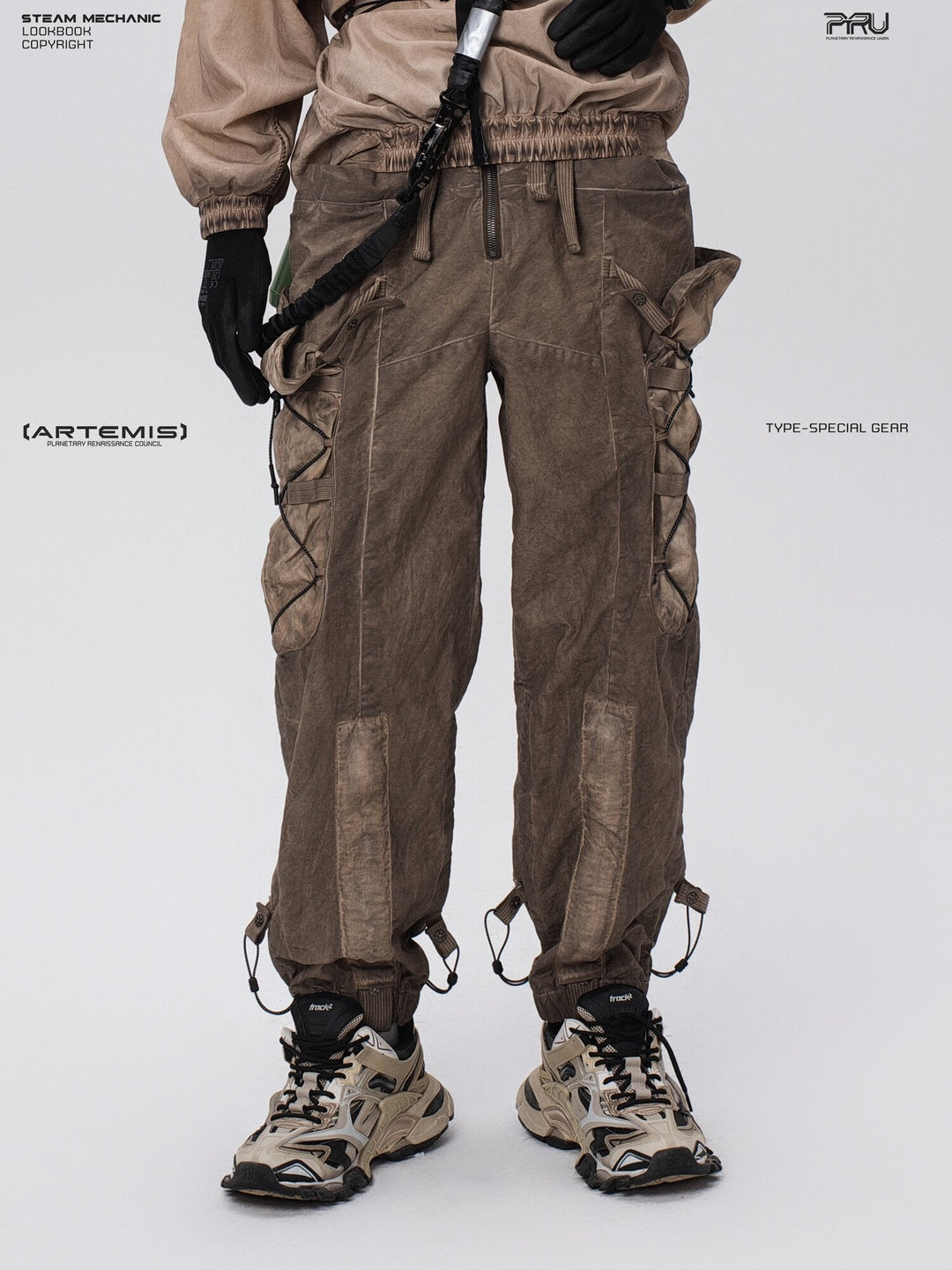 PIONEER detachable waist-pouch cargo pants in gravel brown — front modeled close-up showing the zip fly and long cargo pockets