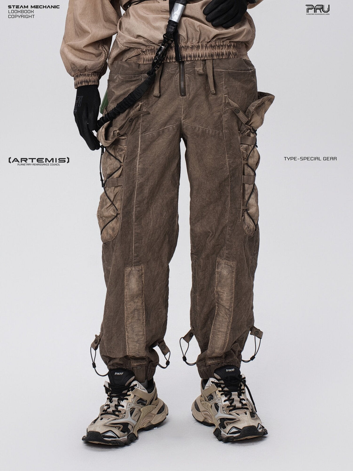 PIONEER detachable waist-pouch cargo pants in gravel brown — front modeled close-up showing the zip fly and long cargo pockets