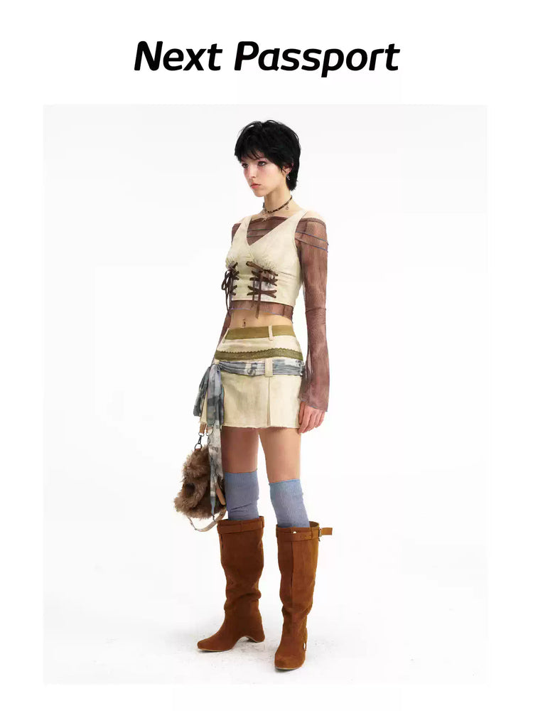 Three-quarter view of the lace-up vest and pleated mini skirt