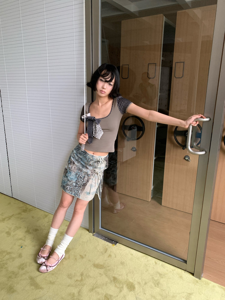4RE1GN BLUE BLOOM tie-front layered skirt in blue multicolor — full-length modeled view beside glass doors