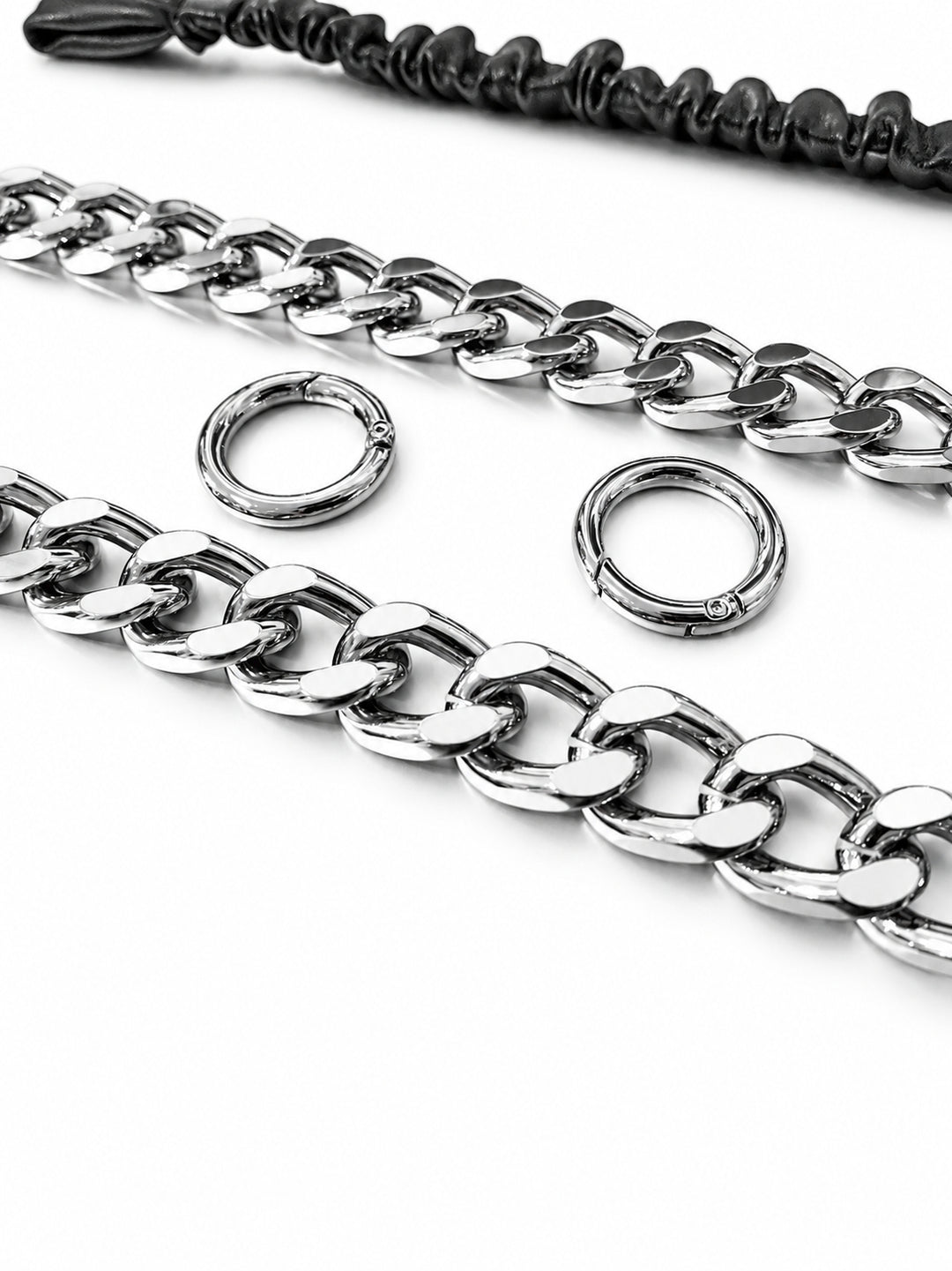 WRAVEN belt silver-tone curb links and round connector hardware, studio close-up.
