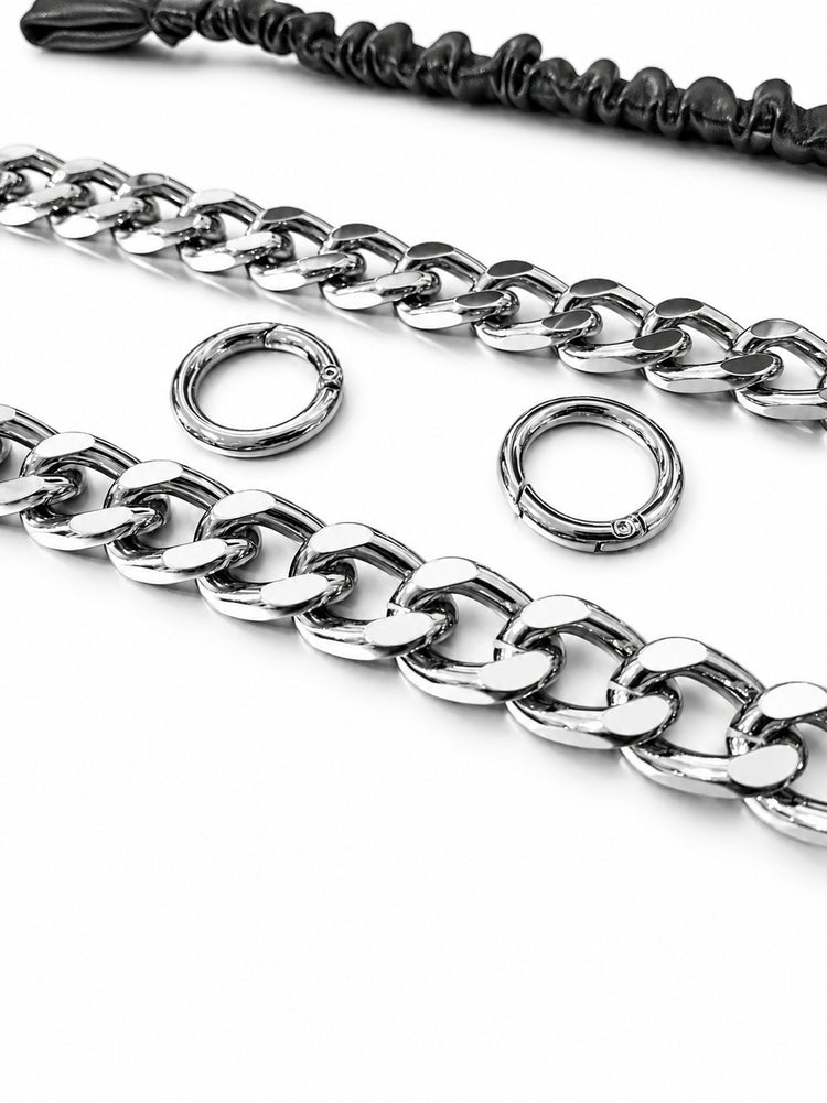 WRAVEN belt silver-tone curb links and round connector hardware, studio close-up.