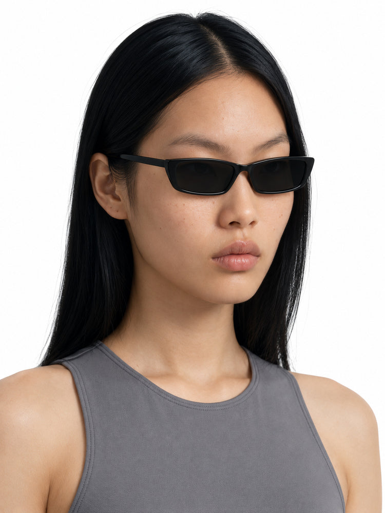 RETRO SPECTRUM black narrow rectangular sunglasses worn by Chell, three-quarter studio view