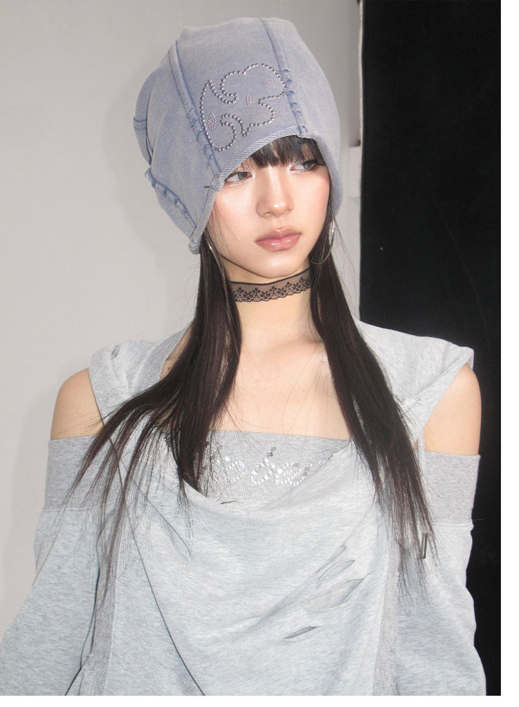 Close studio portrait showing the hoodie neckline and rhinestone hood detail