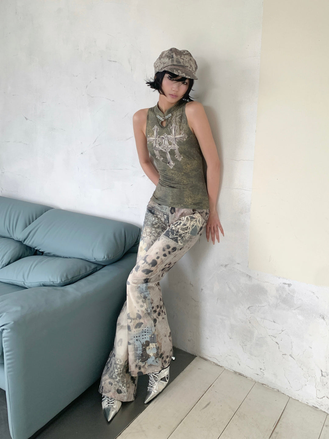 4RE1GN TRIPLE CROSS mandarin sleeveless top in olive green — front modeled view with one hand beside the face
