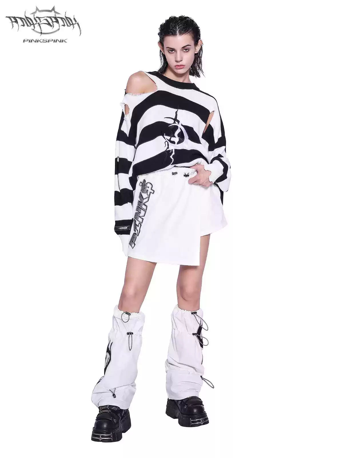 PINKSPINK ELECTRIC MOON distressed striped sweater in BLACK WHITE STRIPE — full-body front view styled with a white skirt and leg warmers.