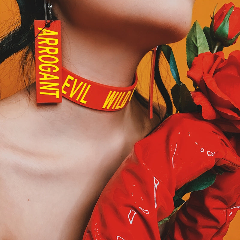 EOH-STUDIO BTBM red EVIL raised-letter choker styled with red earrings and roses; earrings sold separately.