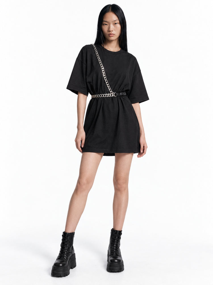Chell wearing the WRAVEN gathered faux-leather chain belt styled at the waist and across the body.