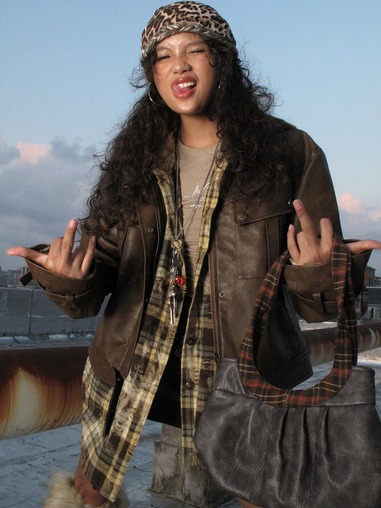 Brown distressed faux-leather moto jacket in a rooftop front view showing its oversized collar and chest pockets