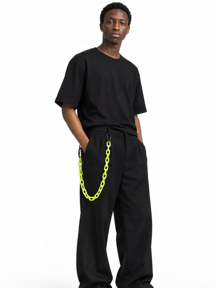 COLLATERAL neon green resin trouser chain styled with black trousers on Derek — AI-generated styling image