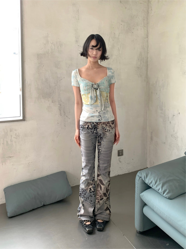 4RE1GN BLUE BLOOM patchwork short-sleeve tee in blue multicolor — front modeled view with arms relaxed and gray leopard-print trousers