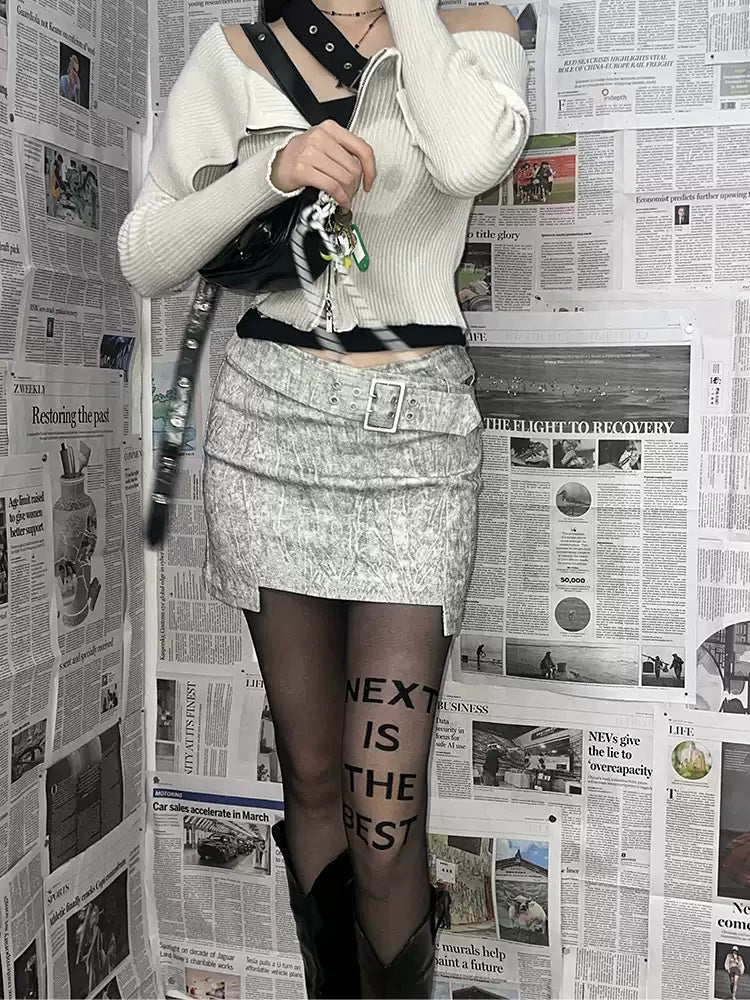 NEXT PASSPORT greige cross-waist belted mini skirt — editorial full-length view.