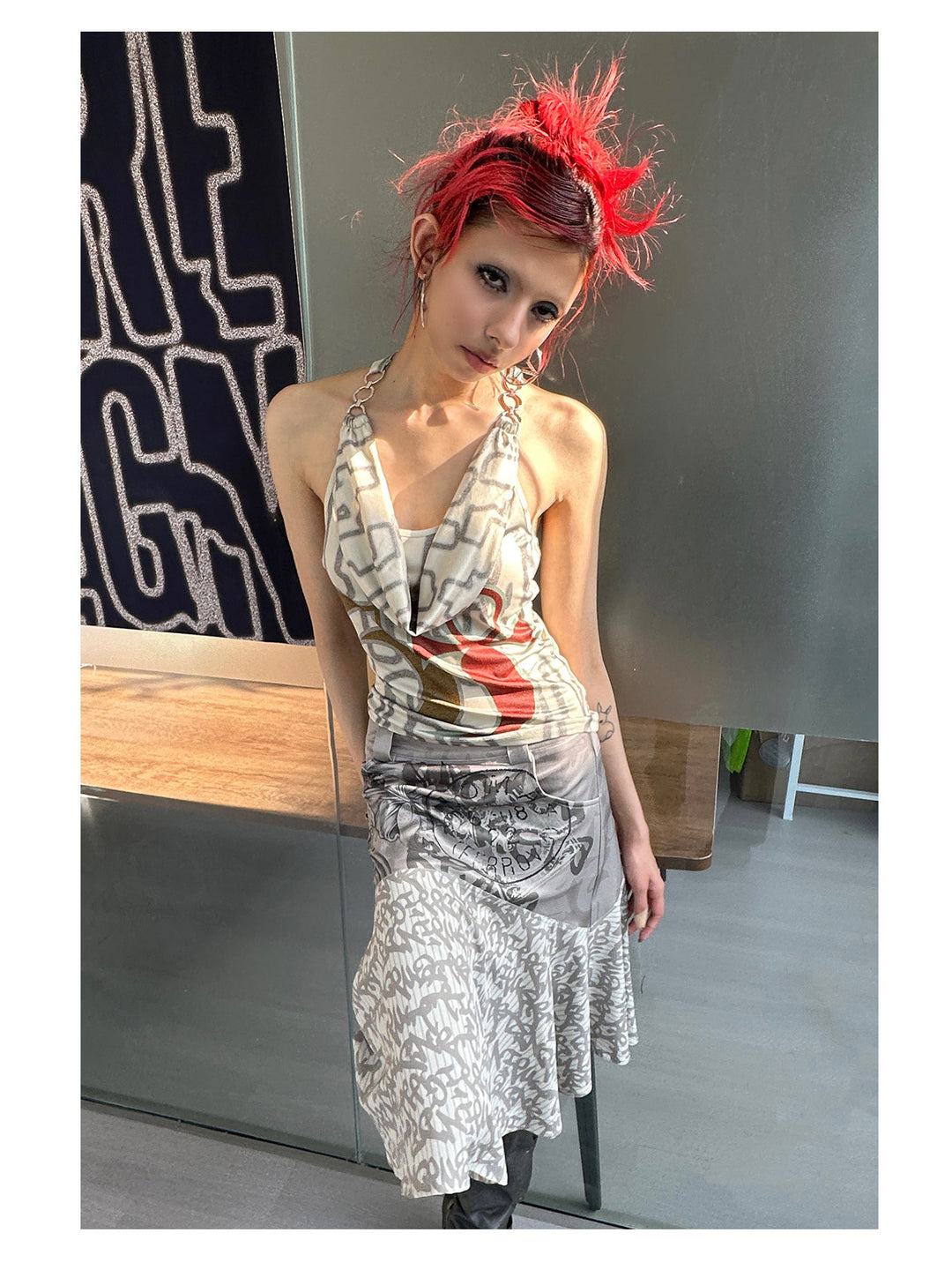 4RE1GN SIGIL cowl-neck halter top in ivory multicolor — front modeled view with a tilted head beside the brand display