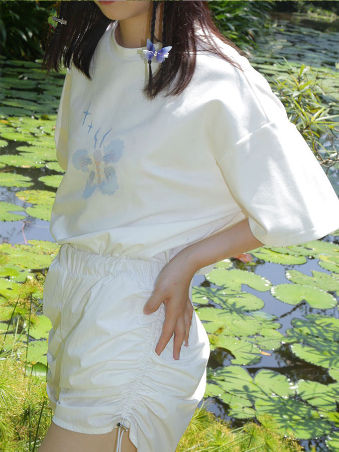 NEXT PASSPORT side-ruched drawstring mini shorts in white, outdoor detail