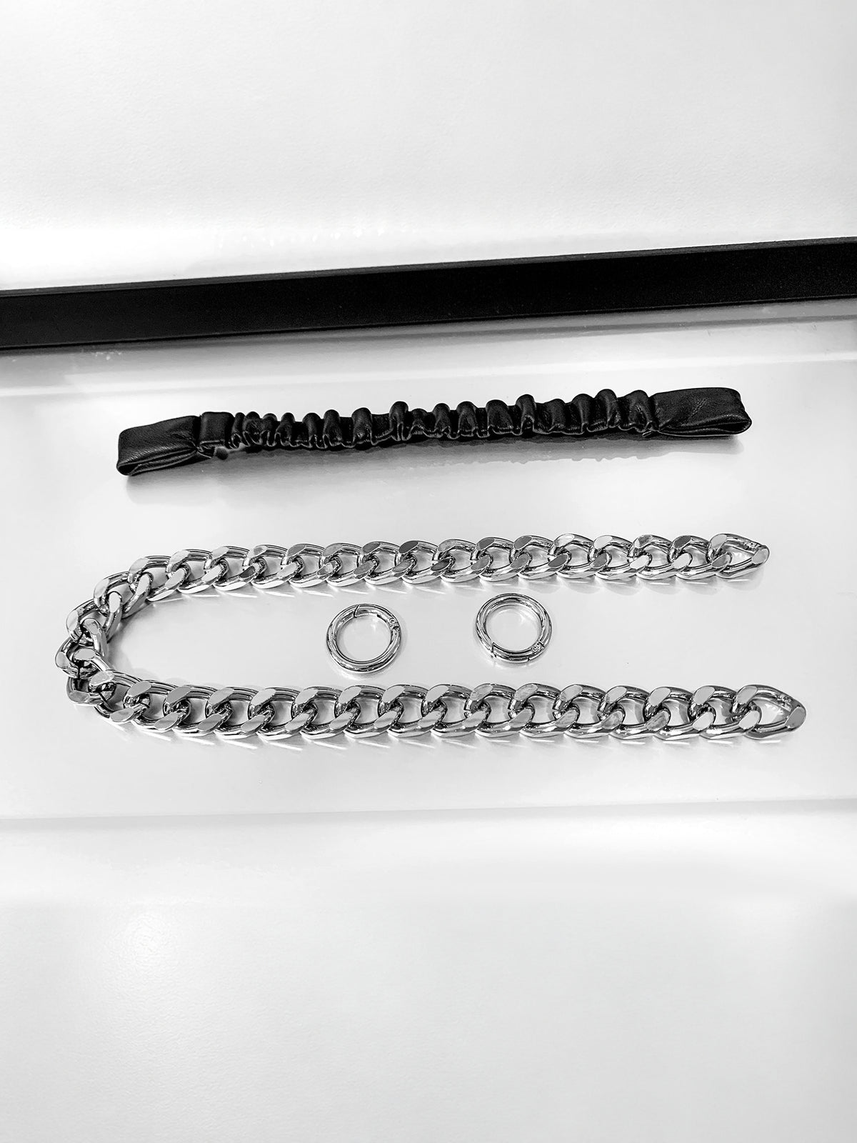 WRAVEN gathered faux-leather curb-chain belt — detached black strap, two round connectors and silver-tone curb chain