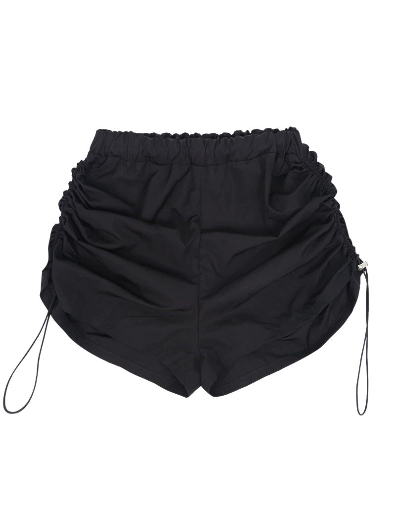 NEXT PASSPORT side-ruched drawstring mini shorts in black, flat lay