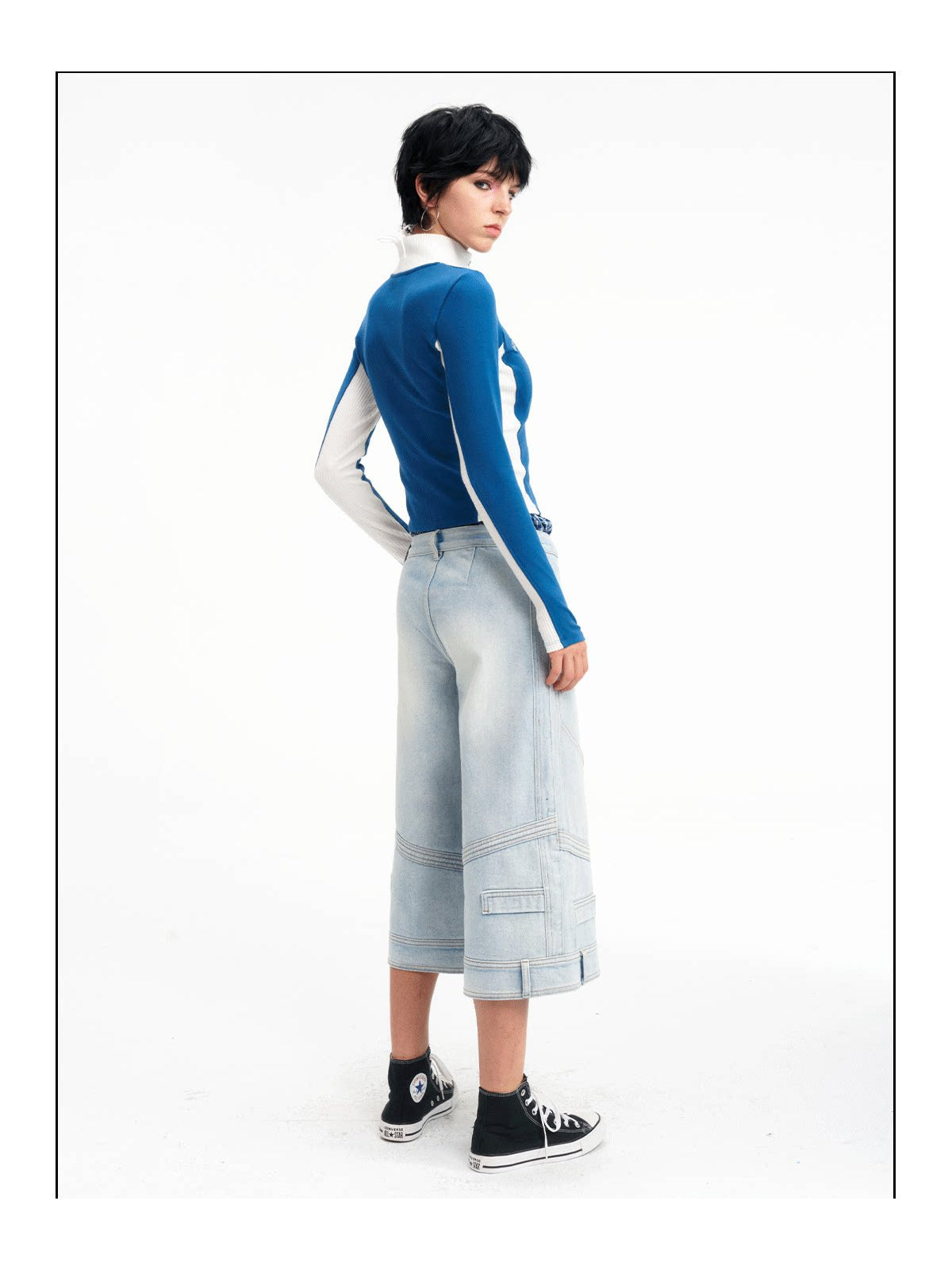 Rear three-quarter studio view of the light-blue cropped jeans