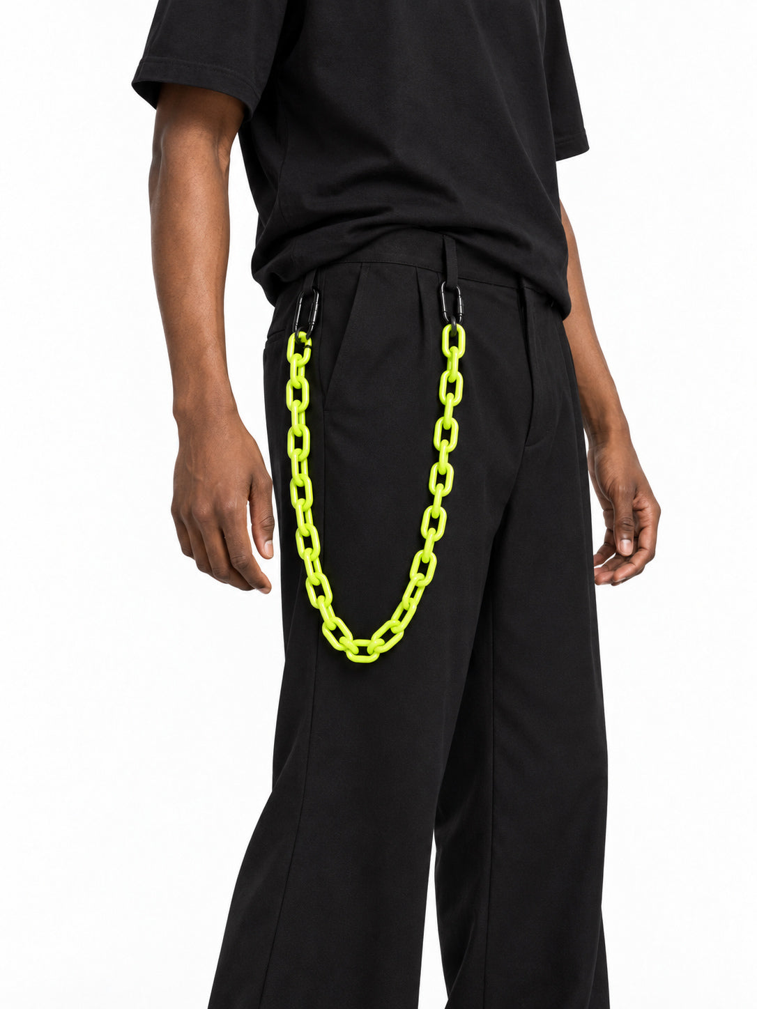 COLLATERAL neon green resin trouser chain close-up, styled with black trousers on Derek — AI-generated styling image