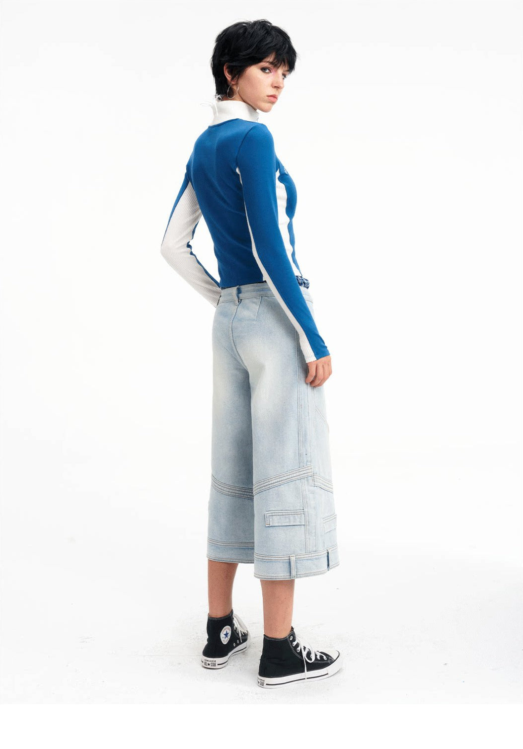 Rear three-quarter studio view of the light-blue cropped jeans