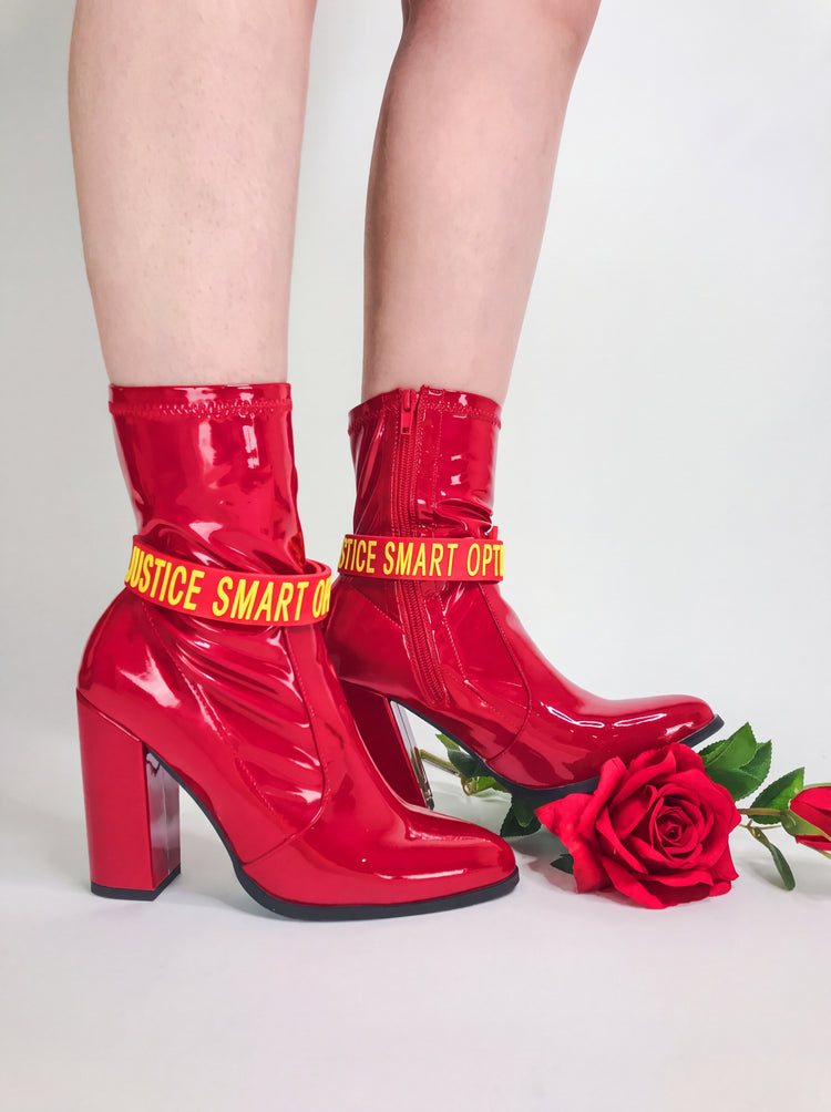 EOH-STUDIO BTBM red raised-letter silicone choker styled around red boots on a clean white studio background.