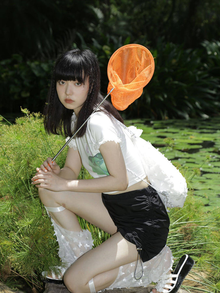 NEXT PASSPORT side-ruched drawstring mini shorts in black, outdoor side view