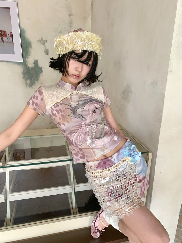 4RE1GN PINK REAPER lace-panel mandarin tee in pink multicolor — three-quarter modeled view leaning against a glass cabinet