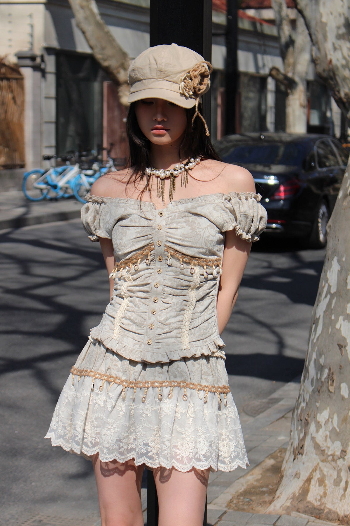 4RE1GN SHELL jacquard blouse and lace skirt separates in ivory — outdoor three-quarter modeled view with the blouse worn off the shoulders
