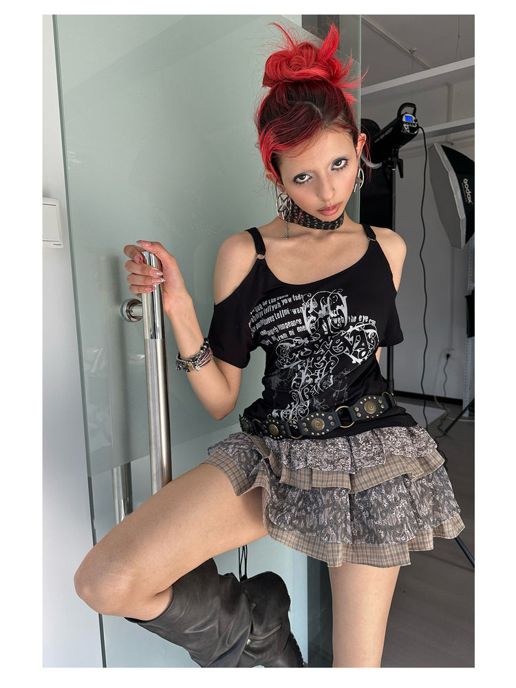 4RE1GN CROSS SCRIPT cold-shoulder tee in black — close modeled view beside the glass door