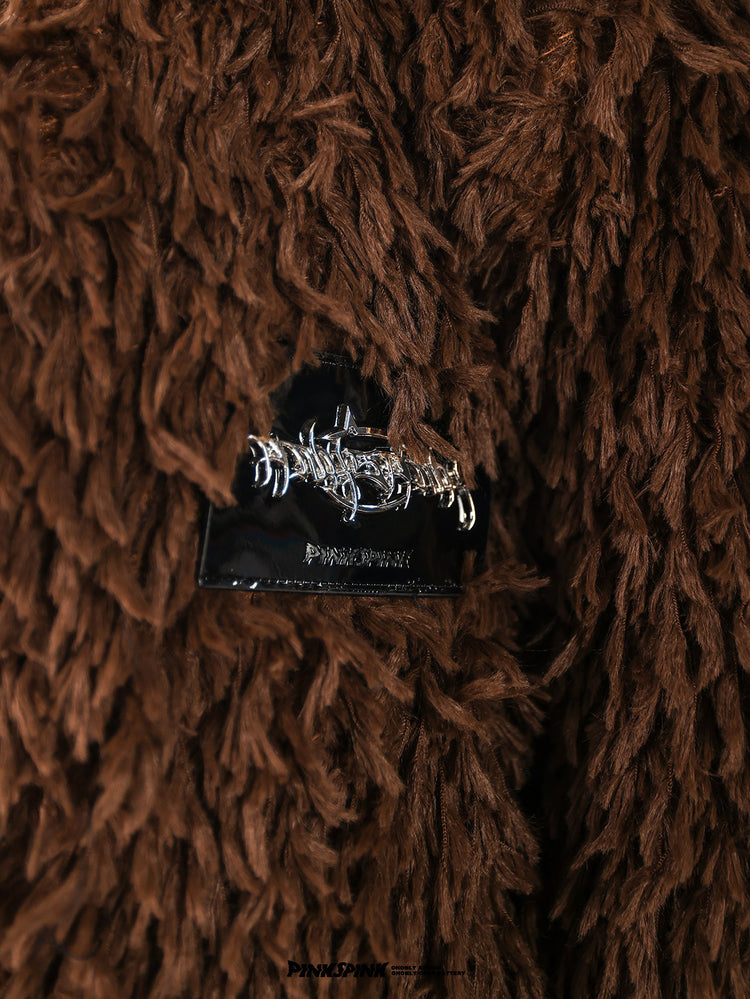 PINKSPINK caramel shaggy padded-shoulder jacket — close-up of the shag fabric and metal logo patch