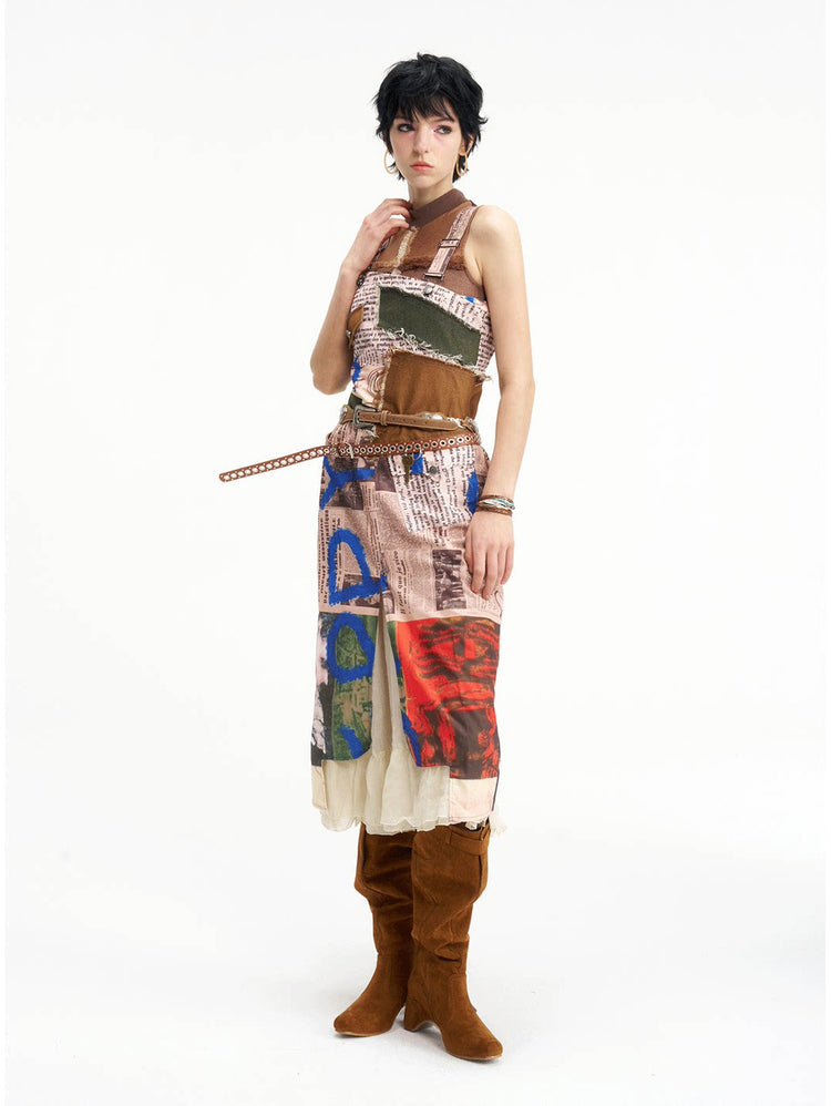 NEXT PASSPORT newspaper-print slit suspender dress — front view with extended waist strap.
