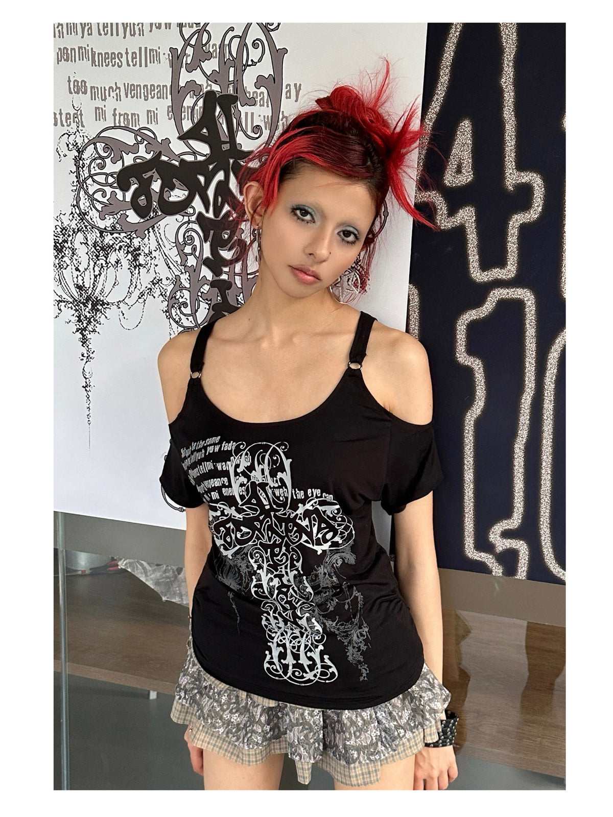 4RE1GN CROSS SCRIPT cold-shoulder tee in black — close front modeled view of the neckline and printed graphic