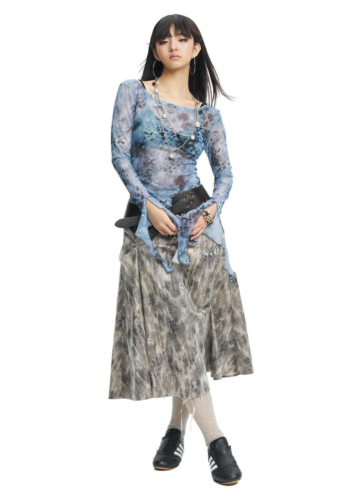NEXT PASSPORT gray crinkled-print midi skirt modeled with hands clasped.