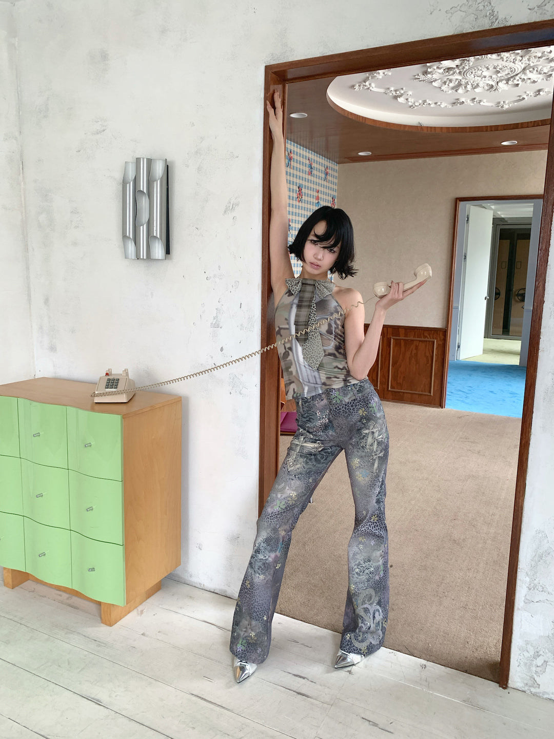 4RE1GN DEAR NINA camouflage tie-neck halter top in camo green — full-length modeled view holding a telephone