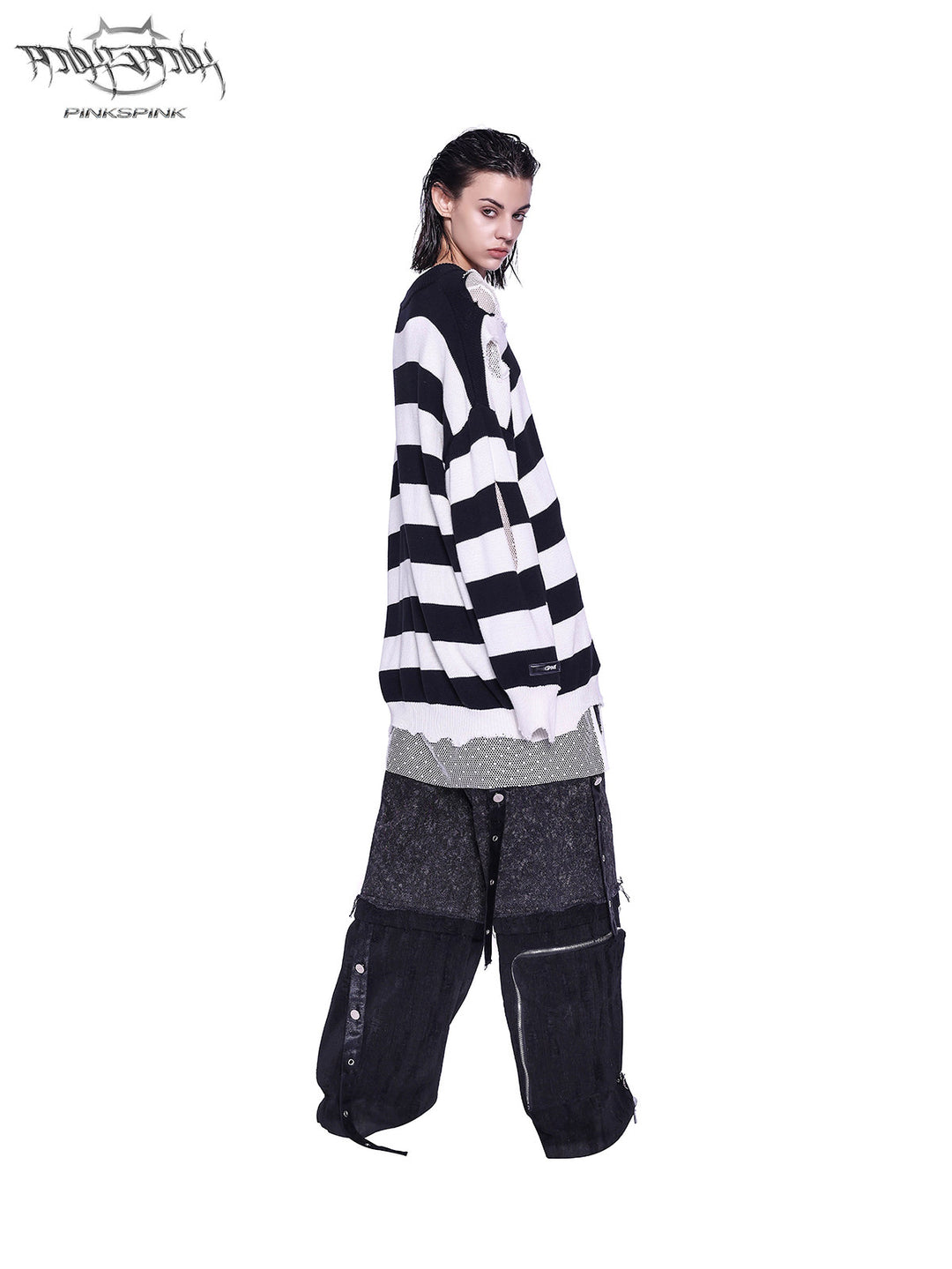 PINKSPINK ELECTRIC MOON distressed striped sweater in BLACK WHITE STRIPE — full-body side view styled with dark cargo trousers.
