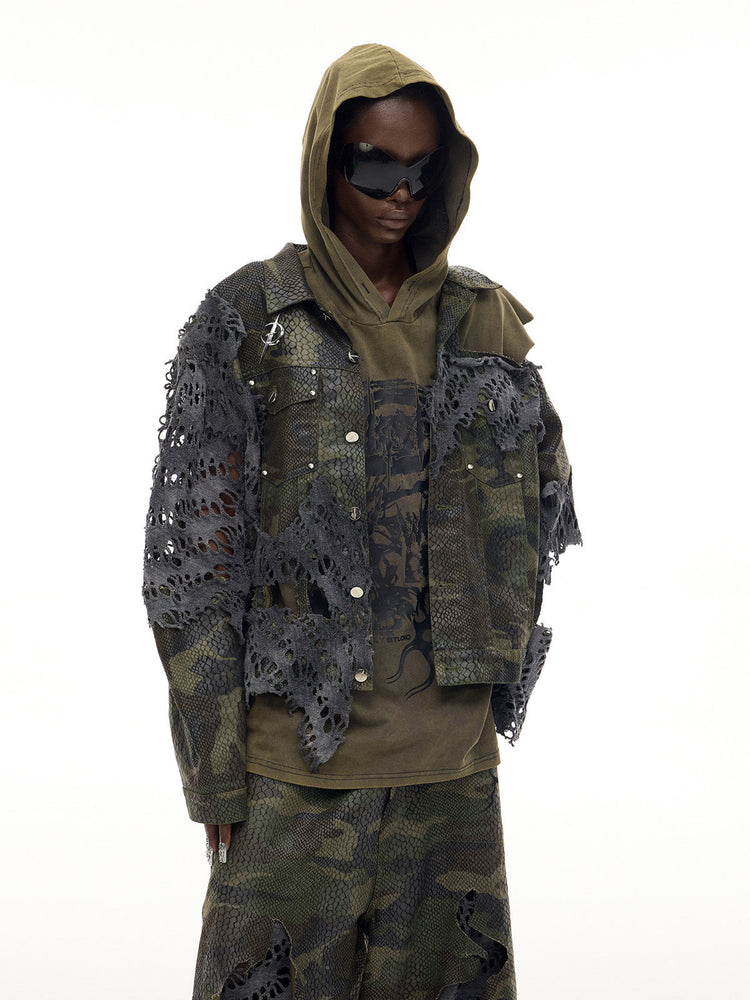 PINKSPINK ELECTRIC MOON distressed camouflage denim jacket — front modeled view with the olive hood raised and hands in pockets