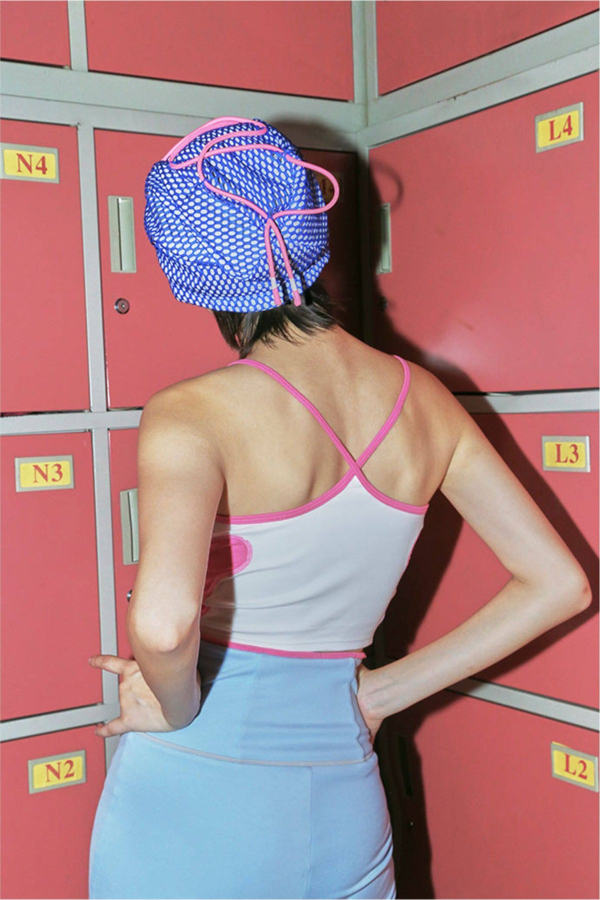 NEXT PASSPORT RETROFUTURE color-block crop camisole — white close back view showing pink crossed straps and hem binding.