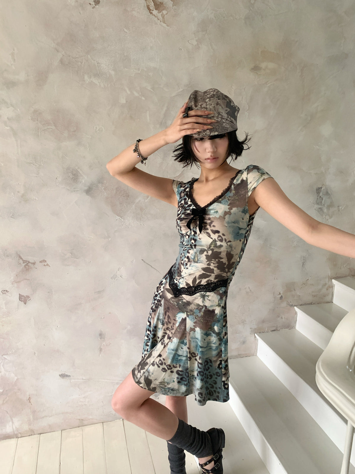 4RE1GN SEA BLUE leopard floral lace dress in gray blue — front modeled view with hand on cap