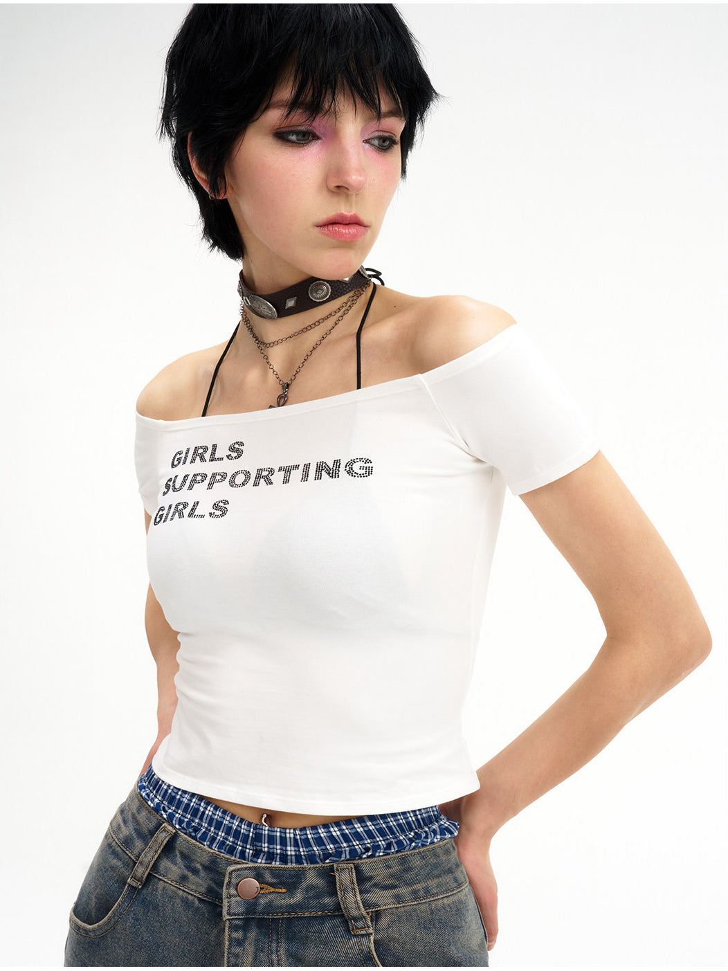 NEXT PASSPORT GIRLS SUPPORTING GIRLS rhinestone off-shoulder crop tee — white close modeled front showing the neckline and slogan.