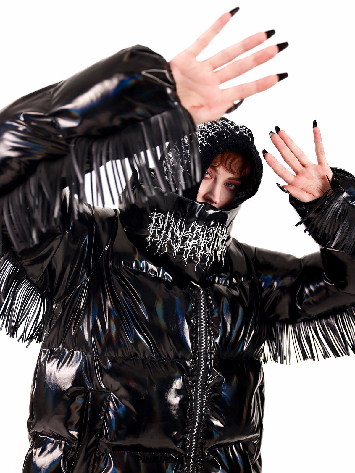 PINKSPINK ELECTRIC THORN embroidered knit balaclava in black — close modeled view with hands raised beside a fringed puffer collar