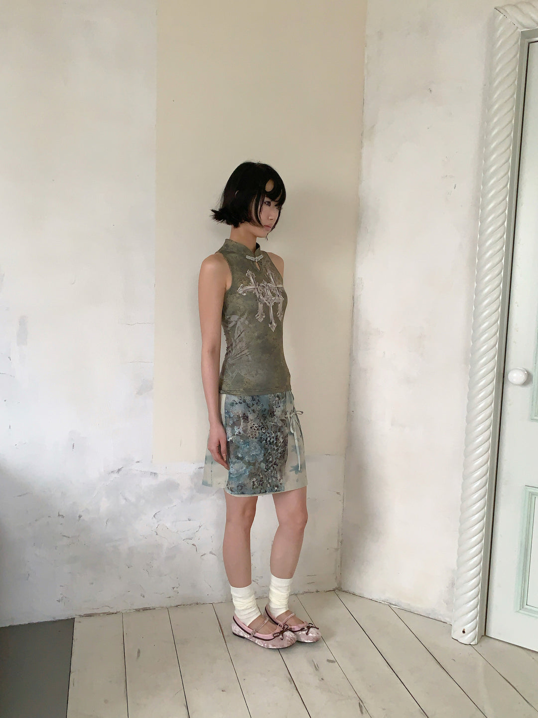 4RE1GN TRIPLE CROSS mandarin sleeveless top in olive green — side modeled view with the BLUE BLOOM layered skirt