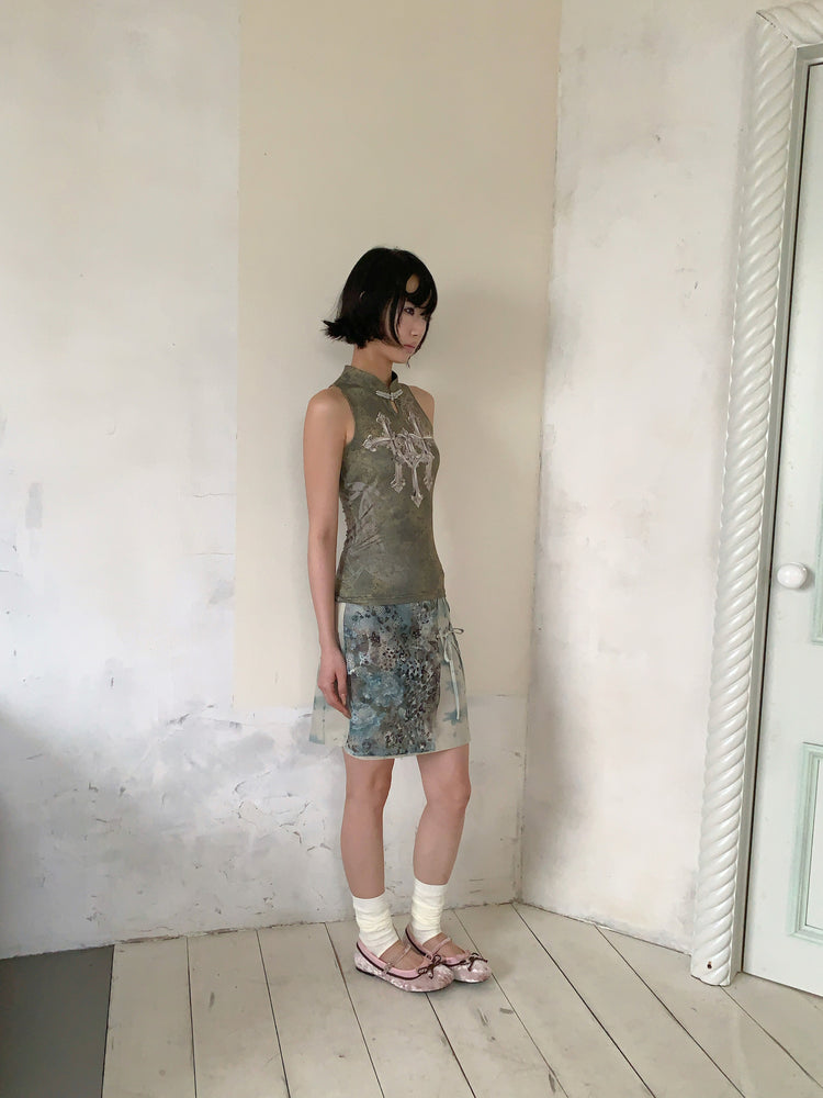 4RE1GN TRIPLE CROSS mandarin sleeveless top in olive green — side modeled view with the BLUE BLOOM layered skirt