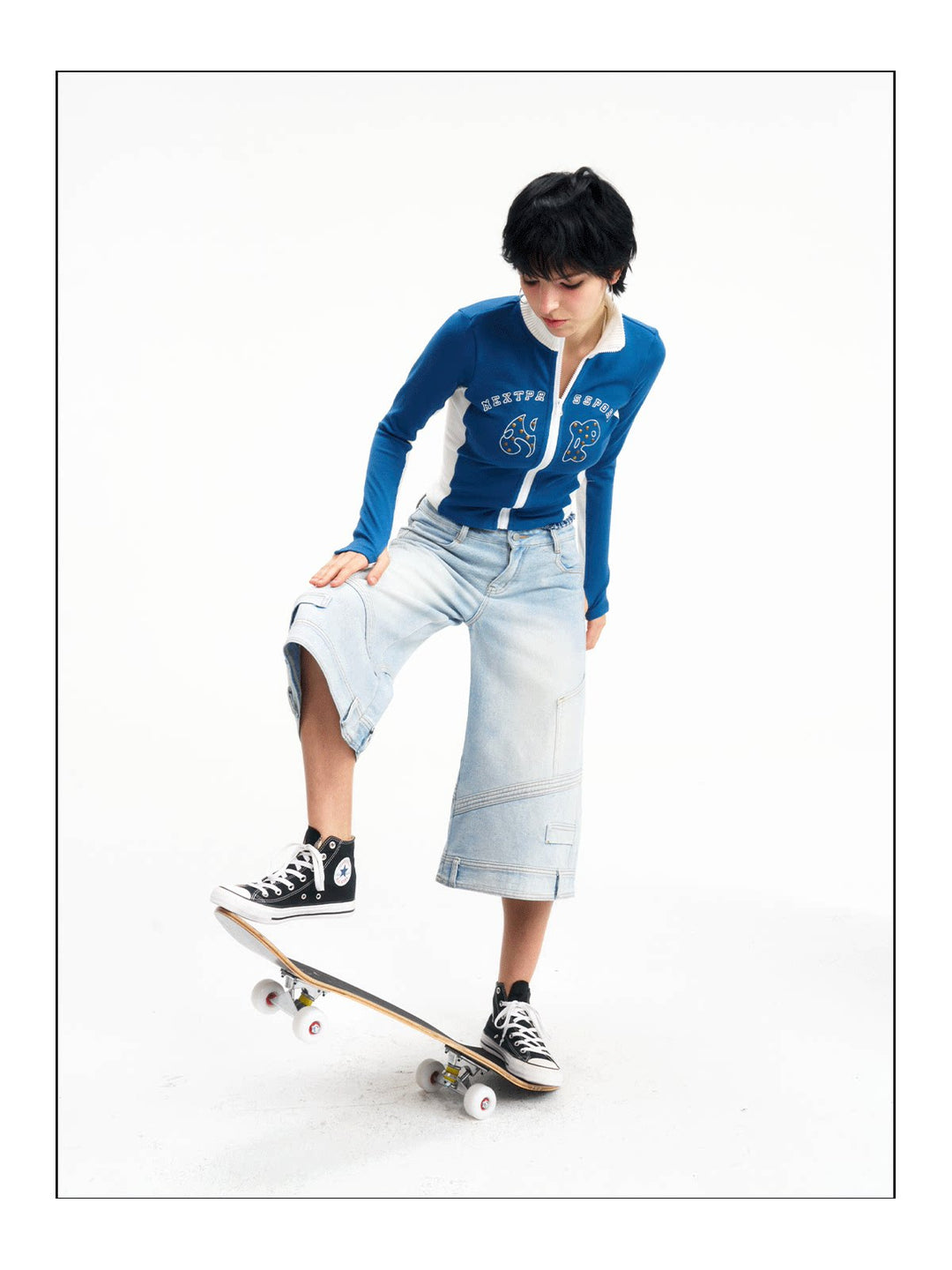 Dynamic studio view of the light-wash wide-leg jeans