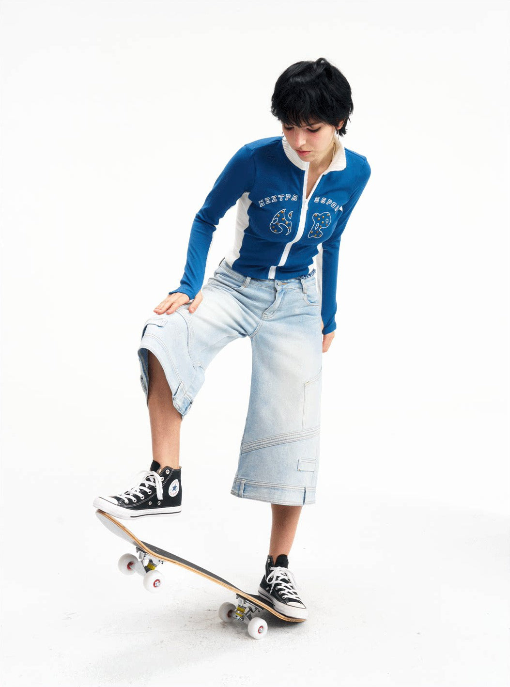 Dynamic studio view of the light-wash wide-leg jeans