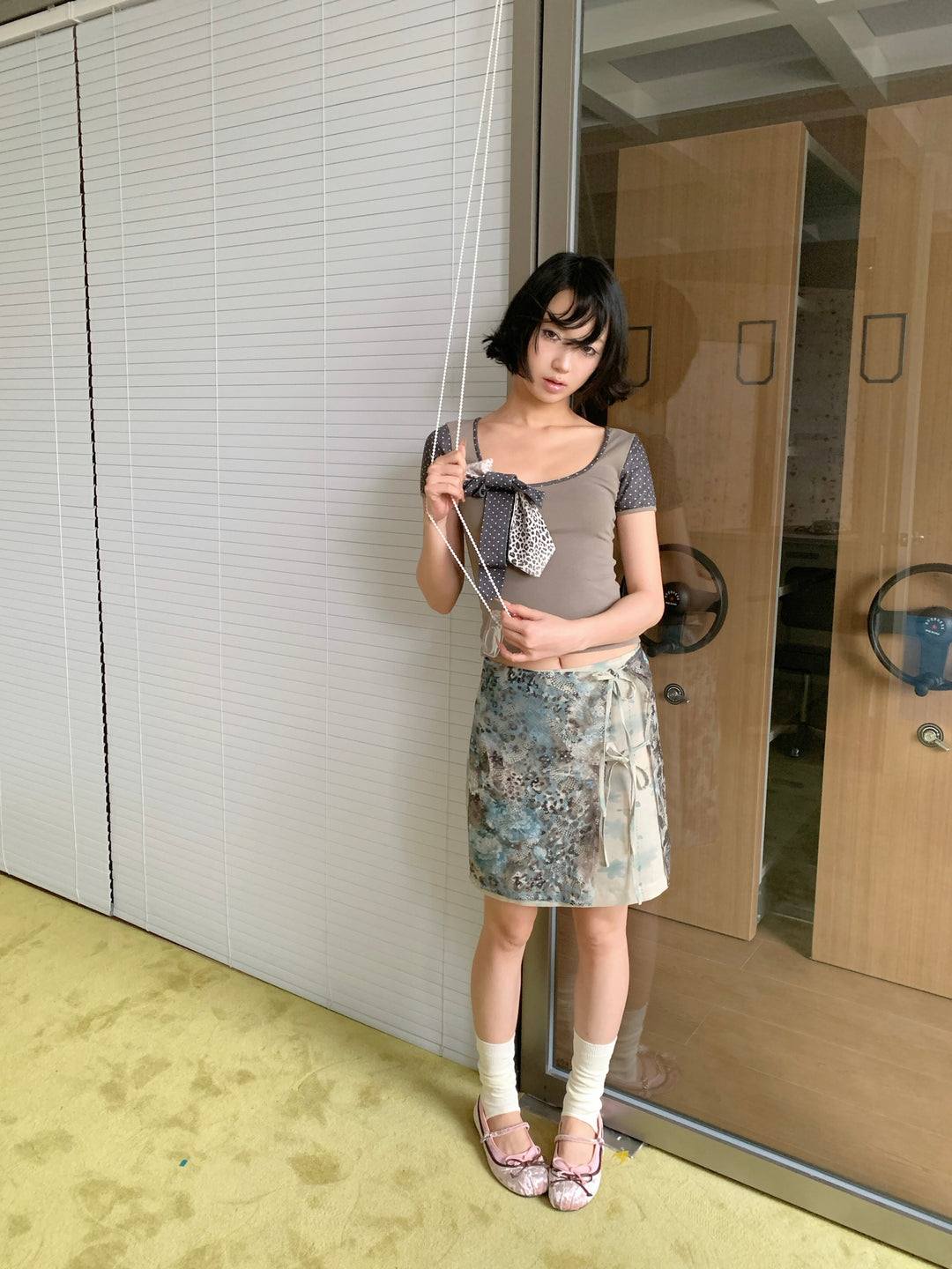 4RE1GN BLUE BLOOM tie-front layered skirt in blue multicolor — front modeled view beside glass doors