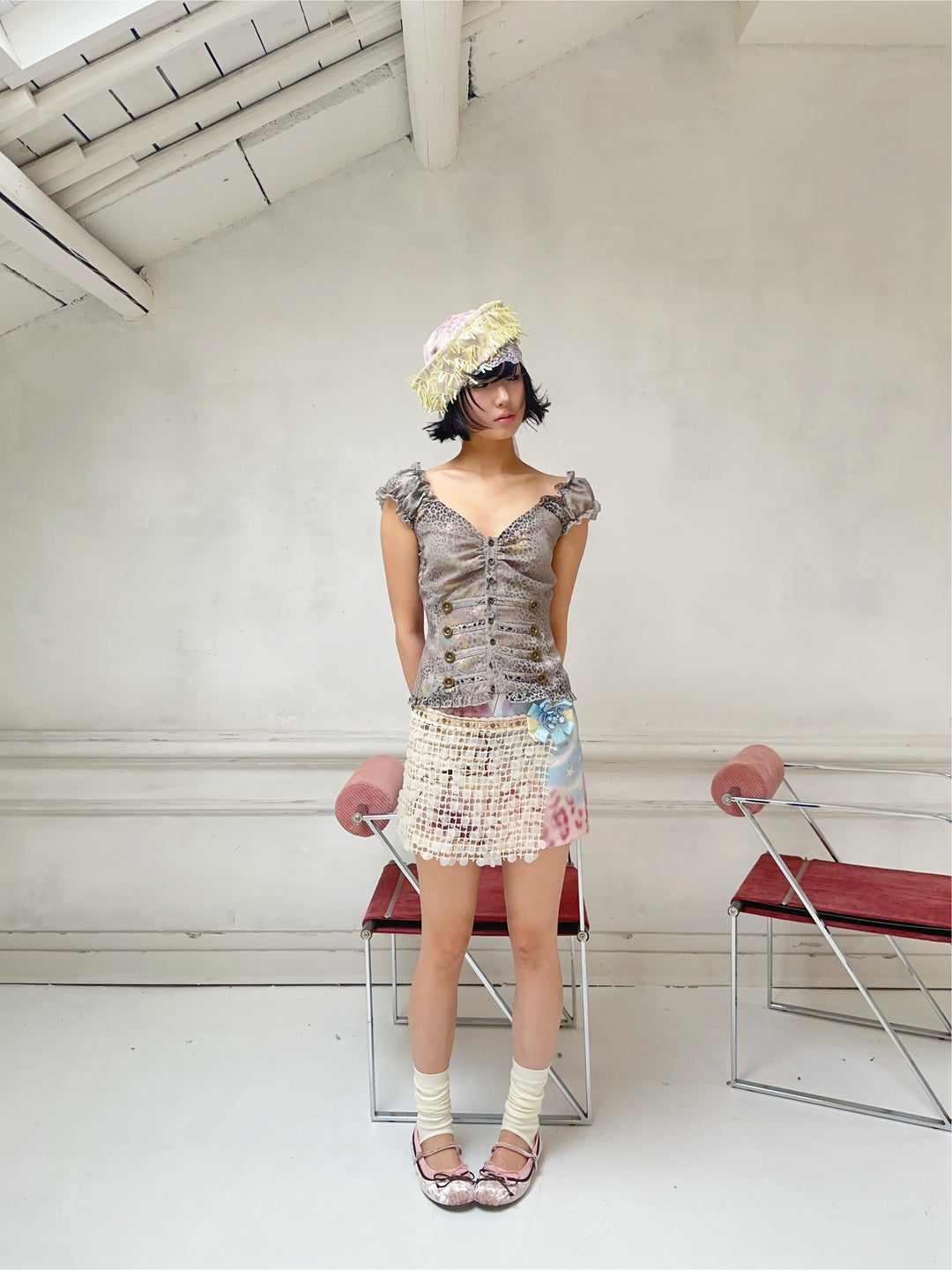 4RE1GN DREAM GARDEN sequin-panel mini skirt in pink multicolor — full-length modeled view with hands behind the back and a gray leopard-print top