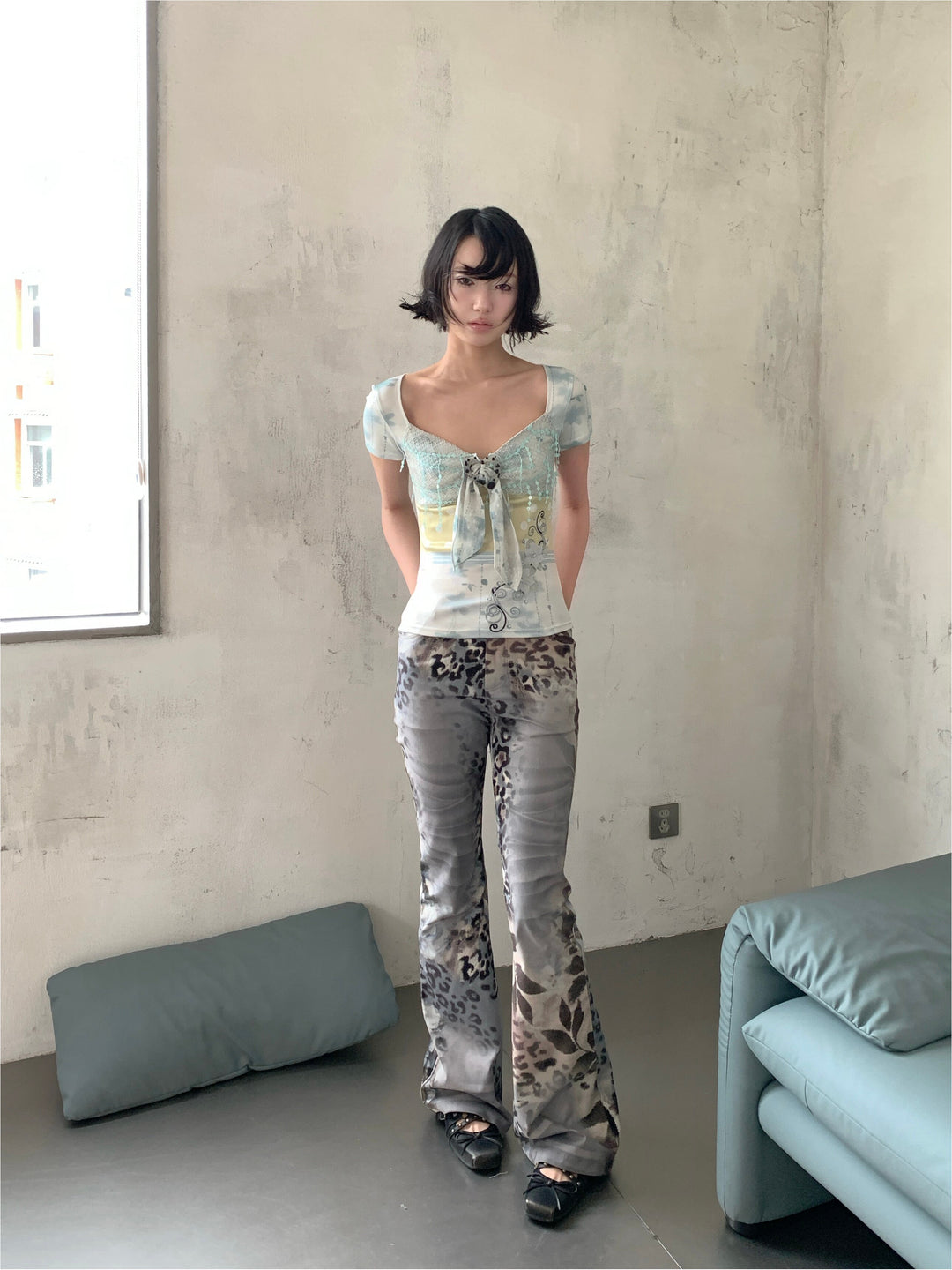 4RE1GN BLUE BLOOM patchwork short-sleeve tee in blue multicolor — front modeled view with hands behind the back