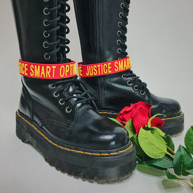 EOH-STUDIO BTBM red BRAVE silicone straps styled around black lace-up boots; boots not included.