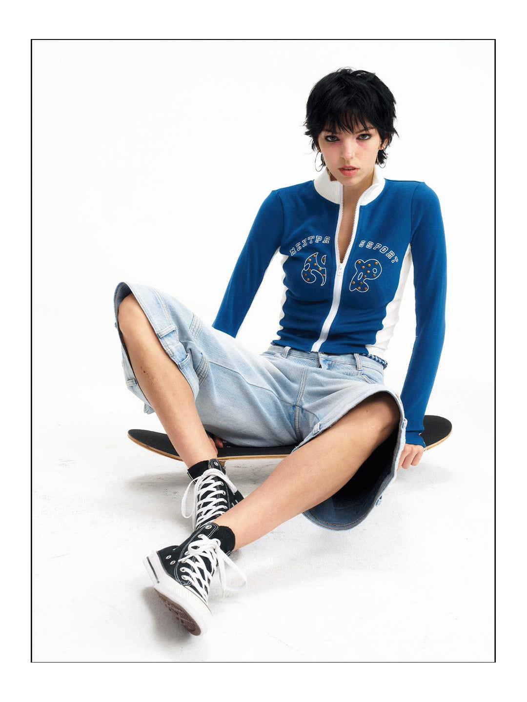 Seated front studio view of the light-blue cropped jeans