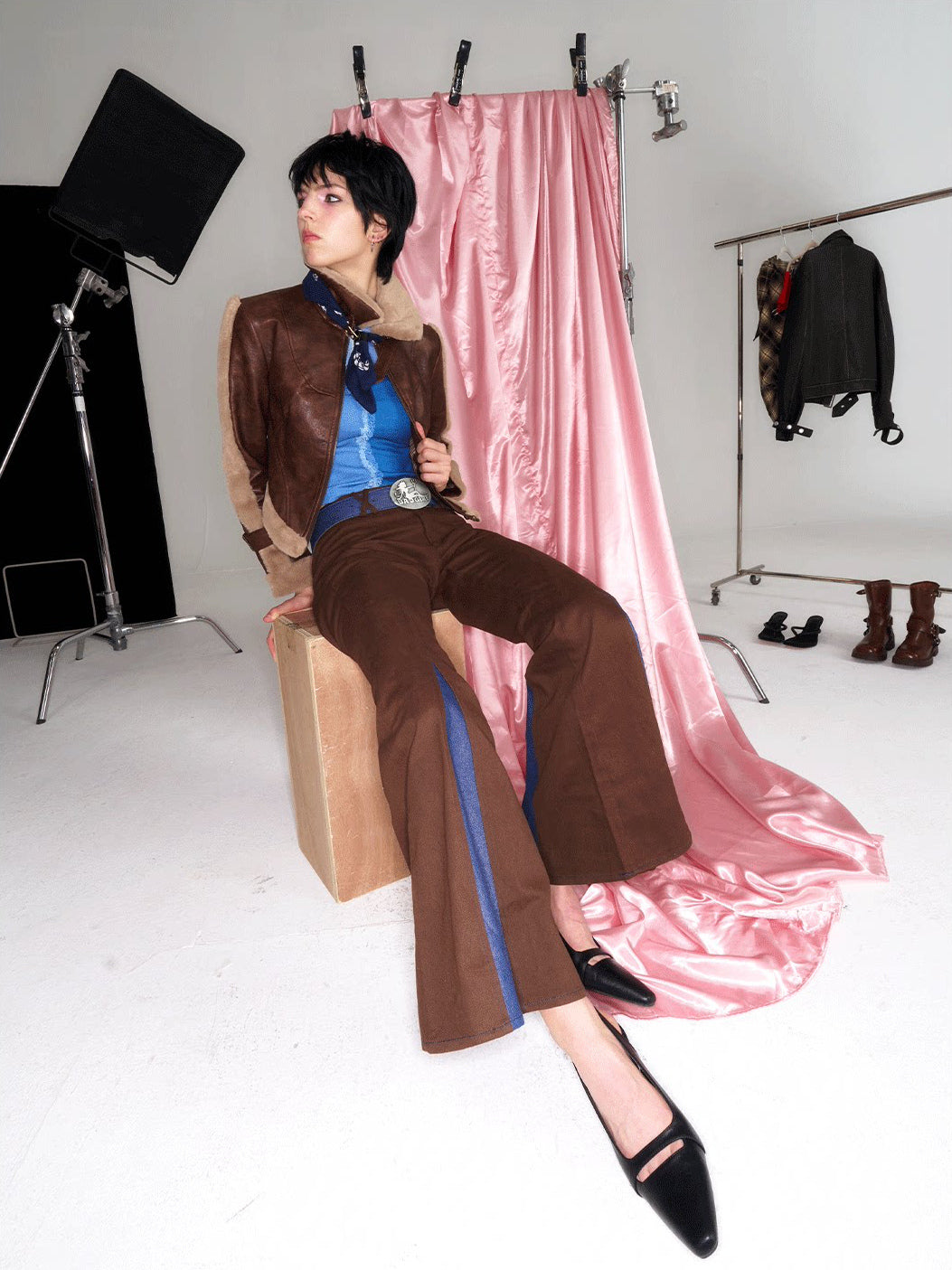 NEXT PASSPORT denim-panel low-rise flared pants in brown — seated styling with a brown jacket.